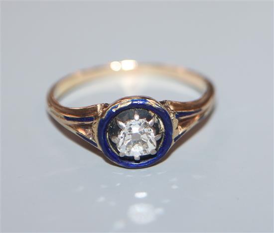 A late Victorian yellow metal solitaire diamond and blue enamel ring, size N.